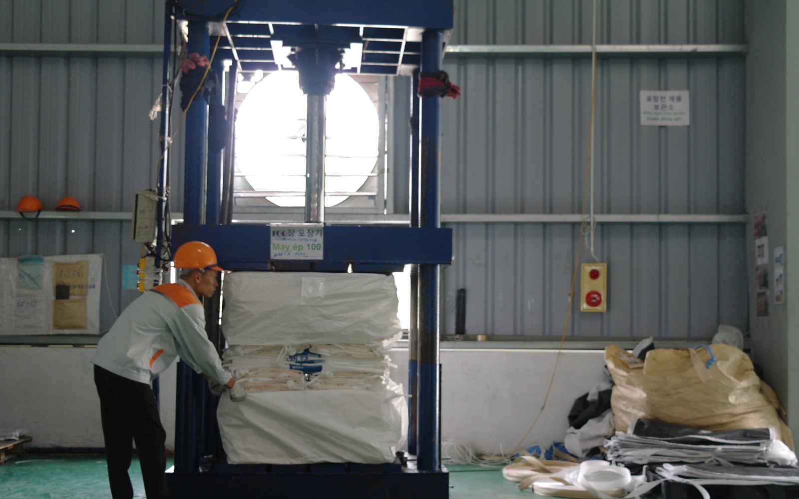 Operator compressing finished bags for packing